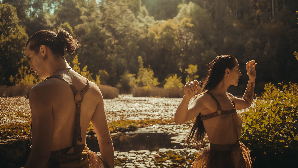 HOMBRE Y MUJER BAILAN CON TORSO DESNUDO EN LAGO CON NENUFARES